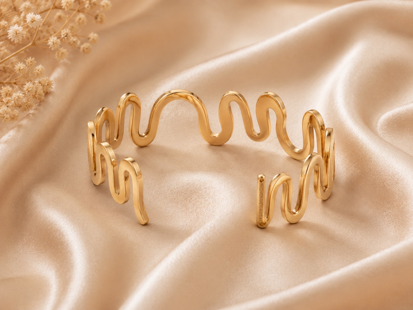 Gold wave cuff bracelet with an open sculptural design and polished finish